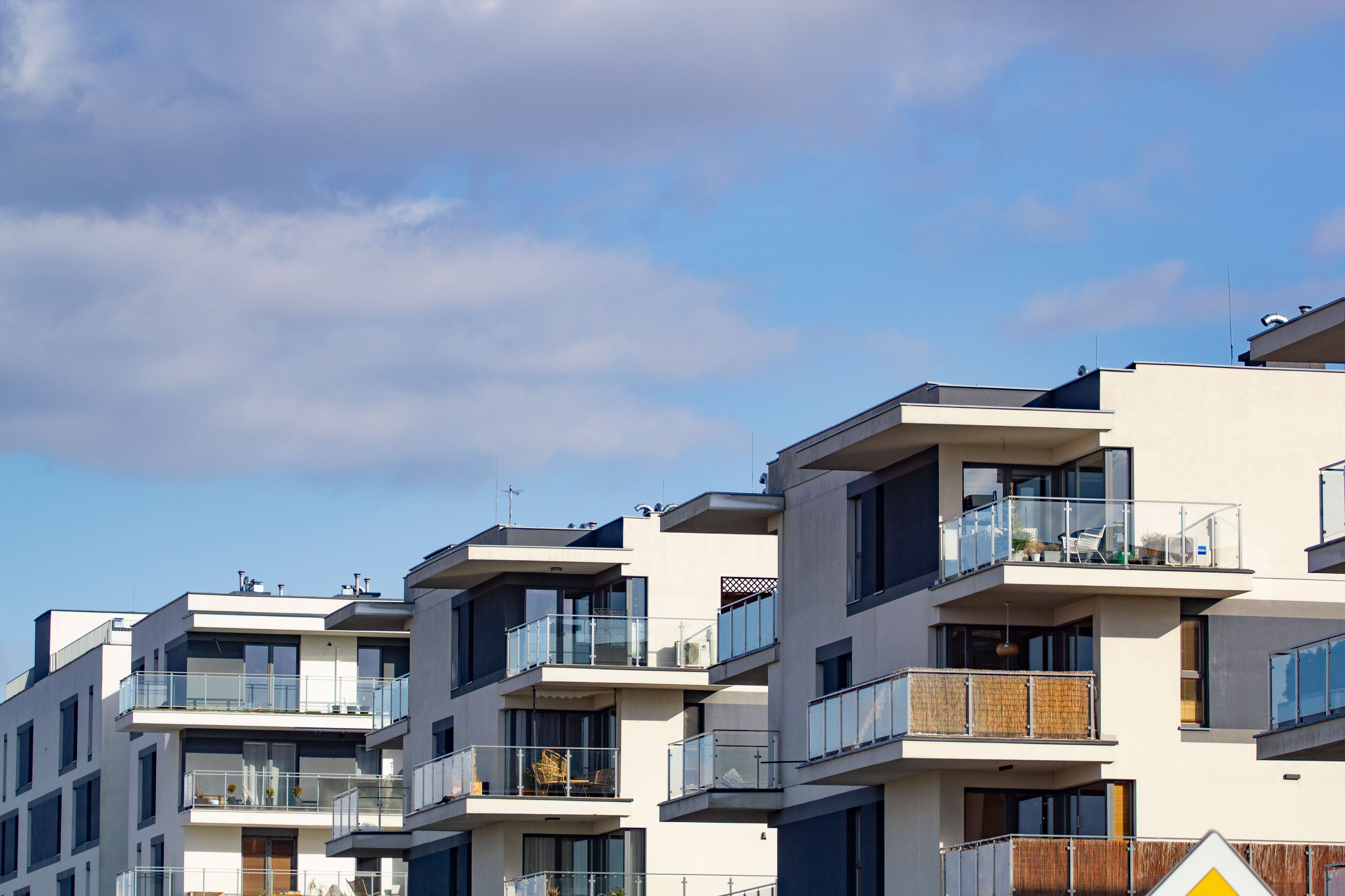 Obrázek row-apartment-buildings-with-balconies-blue-sky.jpg